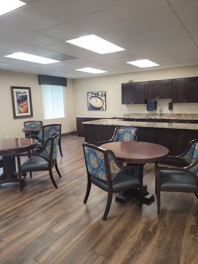 An inviting dining area with wooden tables and chairs, accompanied by a kitchenette.
