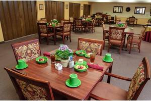 A dining room decorated for St. Patrick's Day with green hats and neatly set tables.