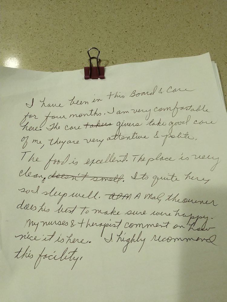 A handwritten review on a sheet of paper secured with a binder clip.