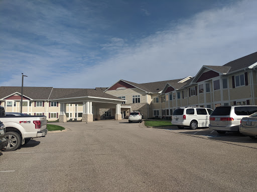 A view of a hotel with a parking area on a cloudy day.