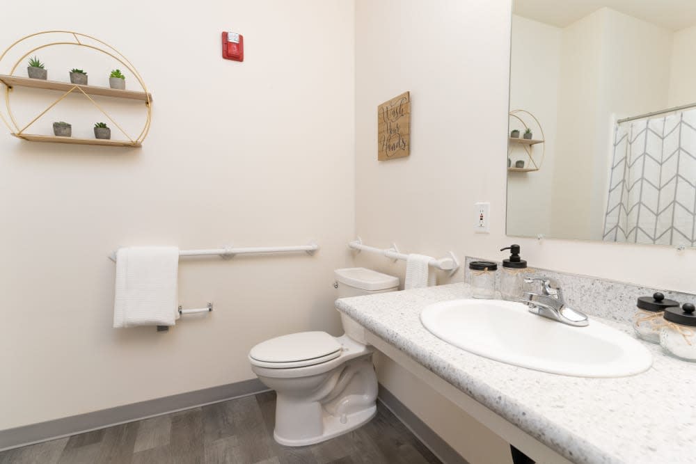 A minimalist bathroom with a toilet, sink, and mirror.
