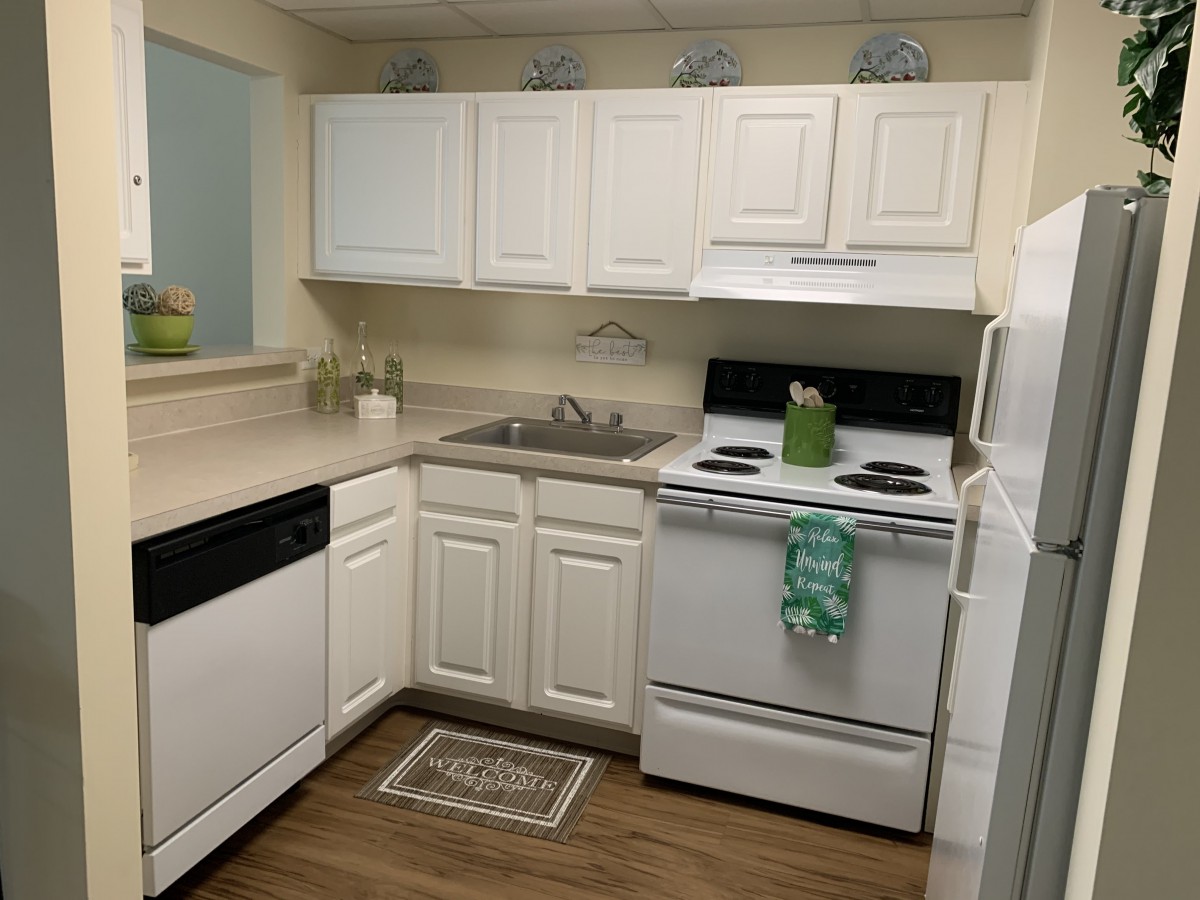 A compact kitchen with white cabinetry and modern appliances.