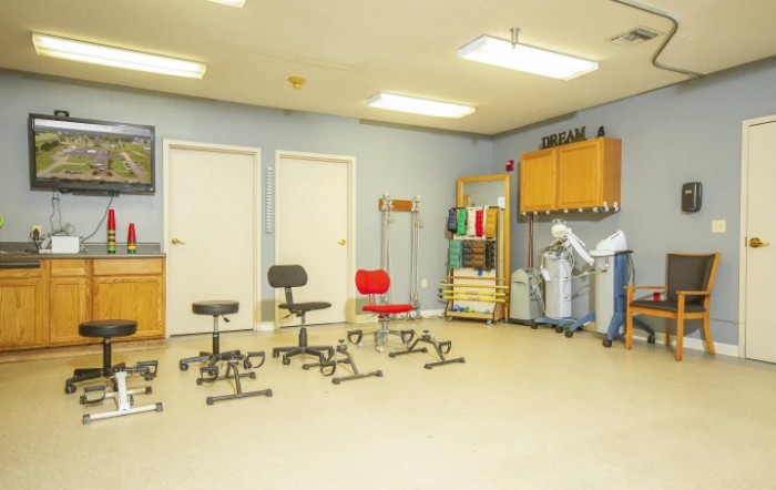 A well-equipped physical therapy room with various exercise tools and seating.