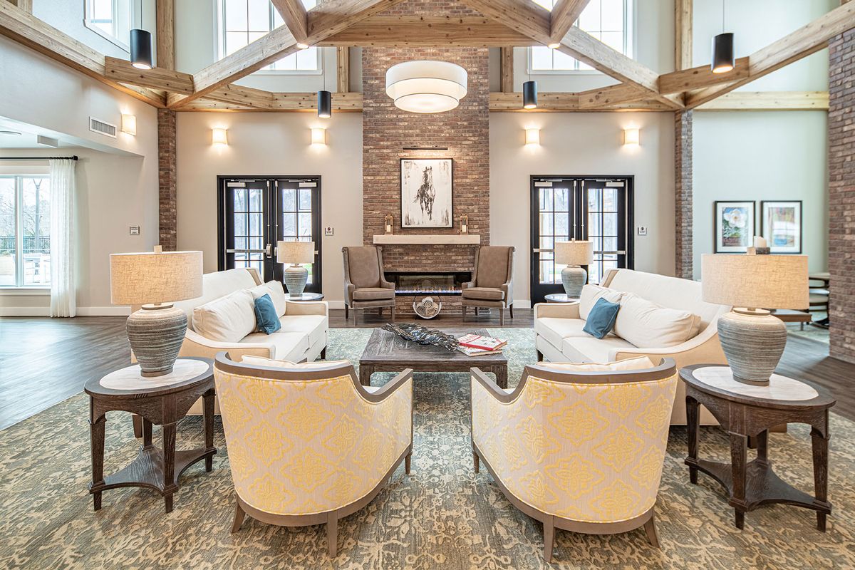 A spacious and elegantly designed living room with modern furniture and a warm fireplace.