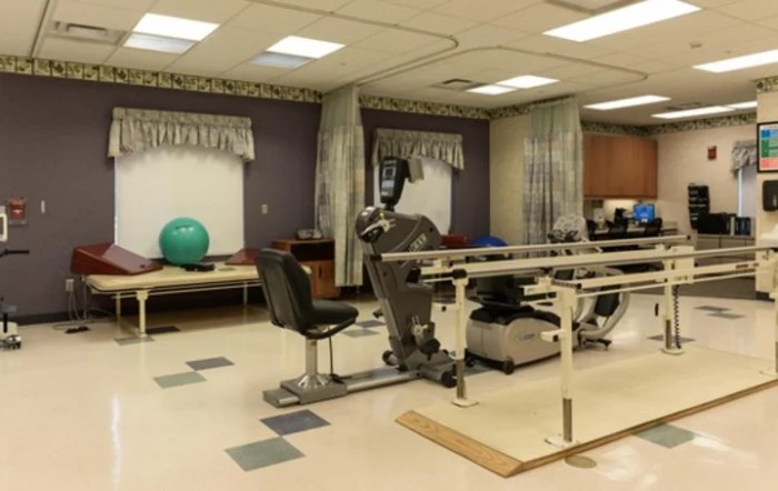 A physical therapy room equipped with exercise machines and rehabilitation tools.