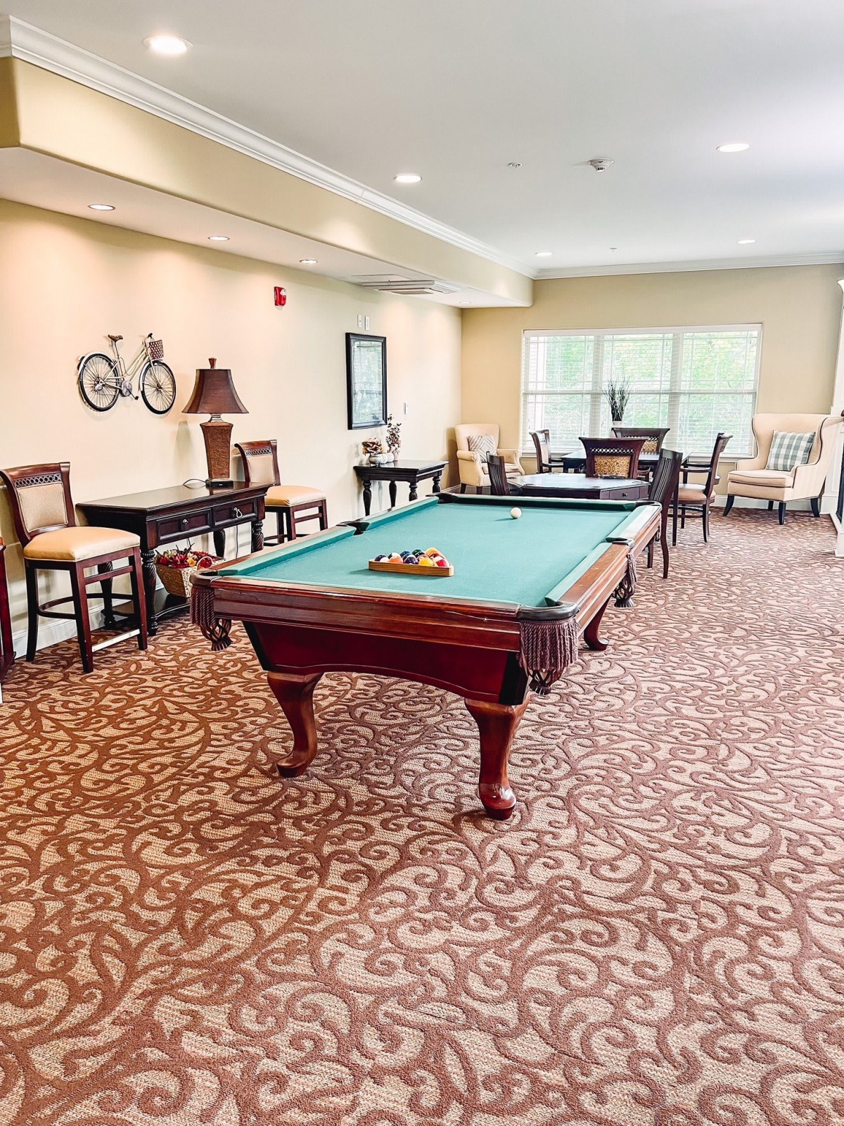 A spacious game room featuring a pool table, decorative elements, and comfortable seating.