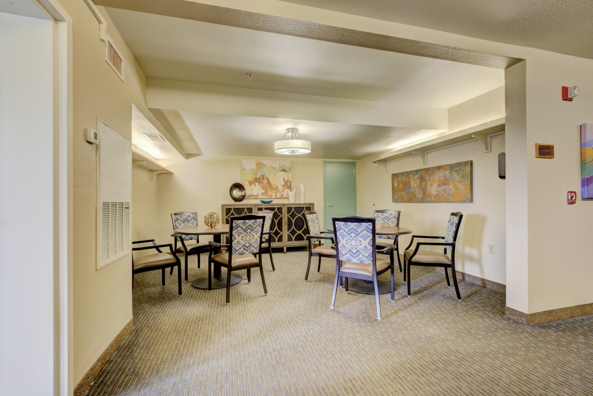 A well-decorated meeting room with tables and chairs arranged for a group discussion.