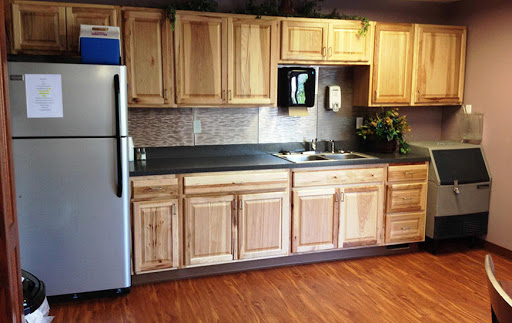 A warm and inviting kitchen featuring natural wooden cabinets and a simple layout.