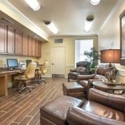 A modern office with computer workstations and a comfortable lounge area.