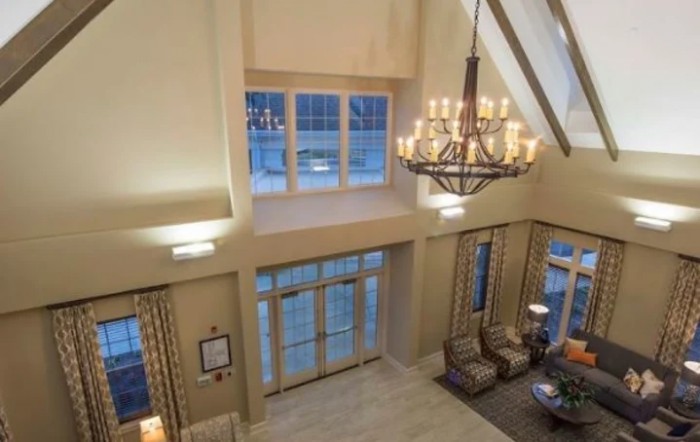 Spacious lobby with a grand chandelier and comfortable seating.