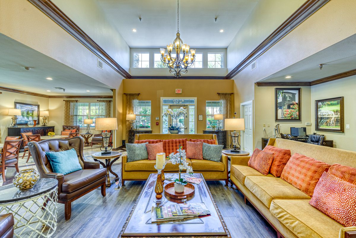 A spacious and elegantly decorated living room with comfortable seating and ambient lighting.