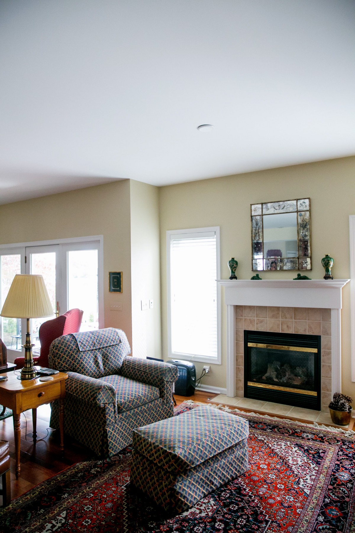 A cozy living room with a fireplace, armchair, and sofa, featuring elegant decor.