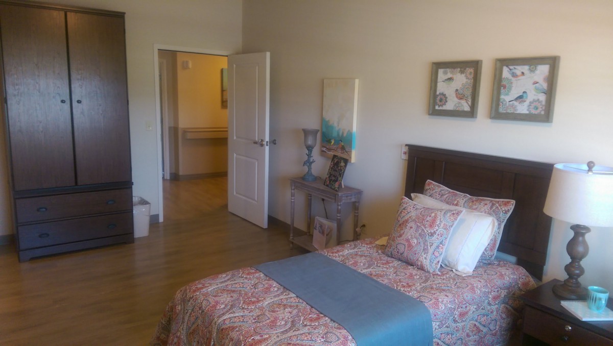 A cozy bedroom with a neatly made bed, decorative pillows, and stylish furniture.