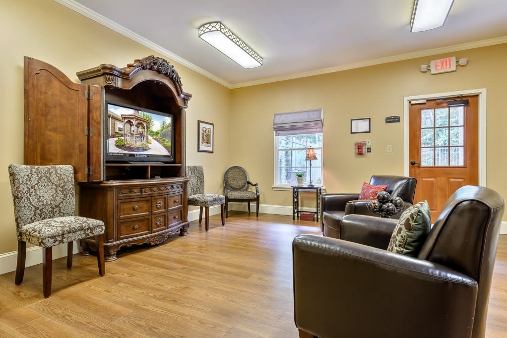 A cozy living room with comfortable seating and a large wooden TV cabinet.