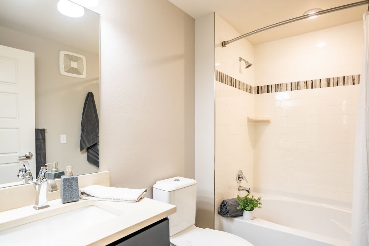 A modern and clean bathroom featuring a bathtub, sink, and mirror.