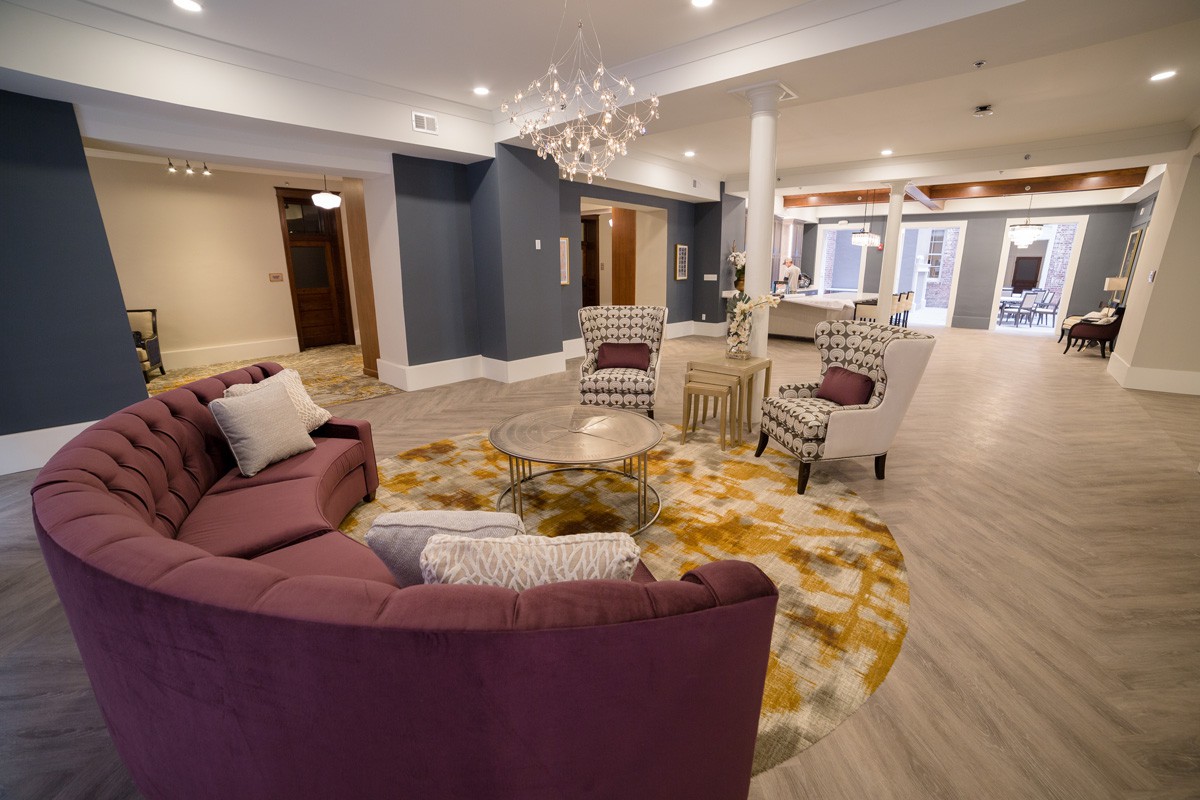 A modern living room with stylish furniture and a contemporary chandelier.
