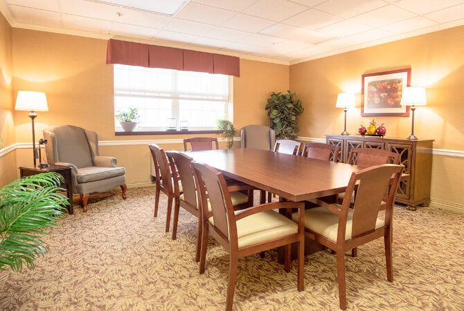A well-lit conference room with a large meeting table and chairs.