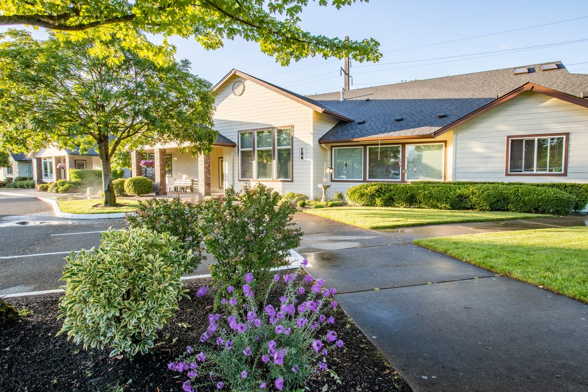 A charming residential house with a well-maintained garden and driveway.