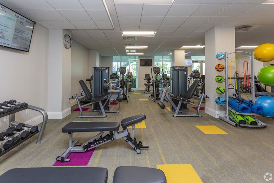 A well-equipped gym with various exercise machines and weights.