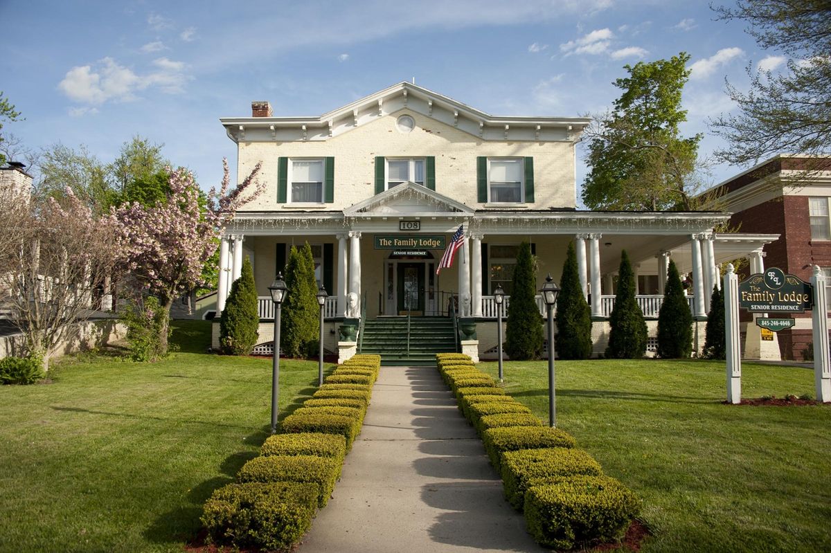 A beautiful two-story house with a well-maintained garden path leading to the front porch.