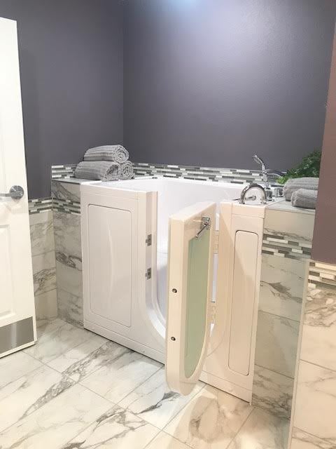 A modern bathroom featuring an accessible walk-in bathtub with open door.