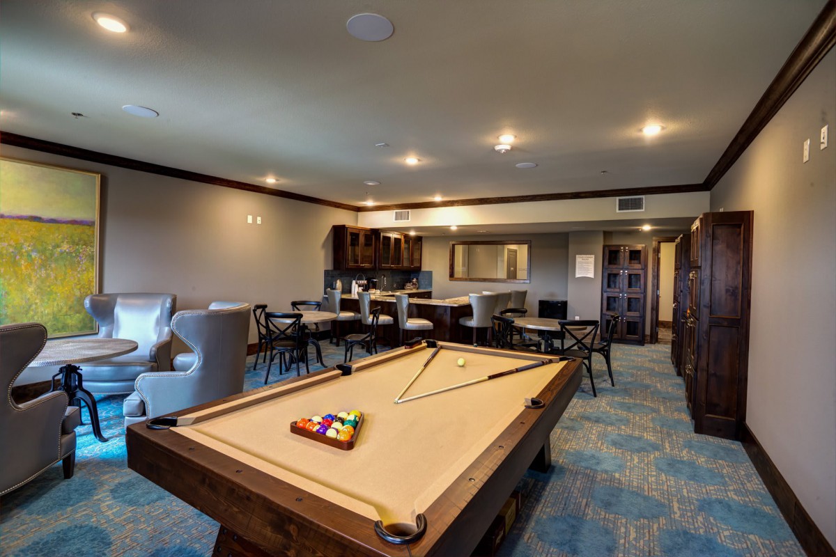 A spacious game room with a pool table and seating area.