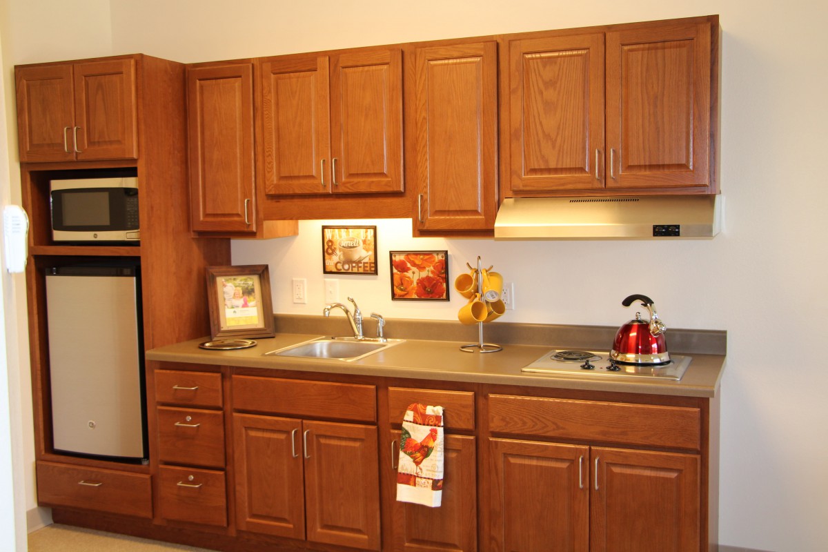 A cozy kitchen with wooden cabinets, a sink, stove, and decorative elements.
