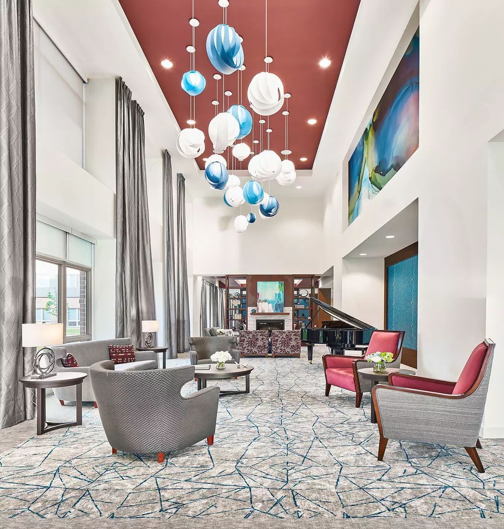 A modern lobby with stylish furniture and unique chandeliers.