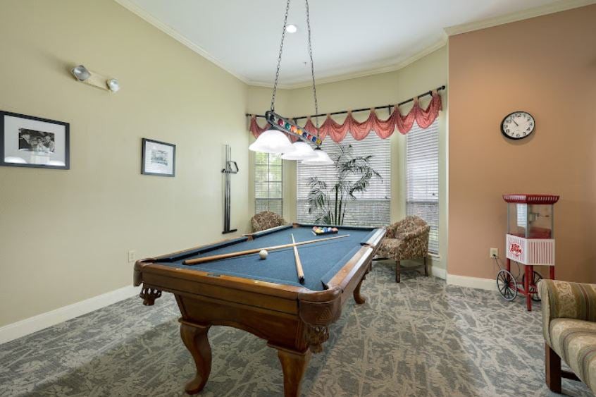 A stylish billiard room featuring a classic pool table and elegant interior design.