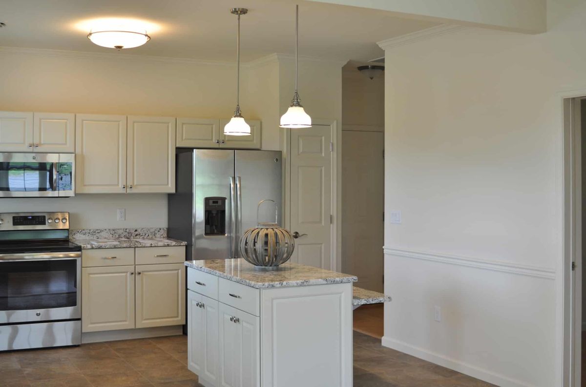 A modern kitchen with a central island and pendant lighting.
