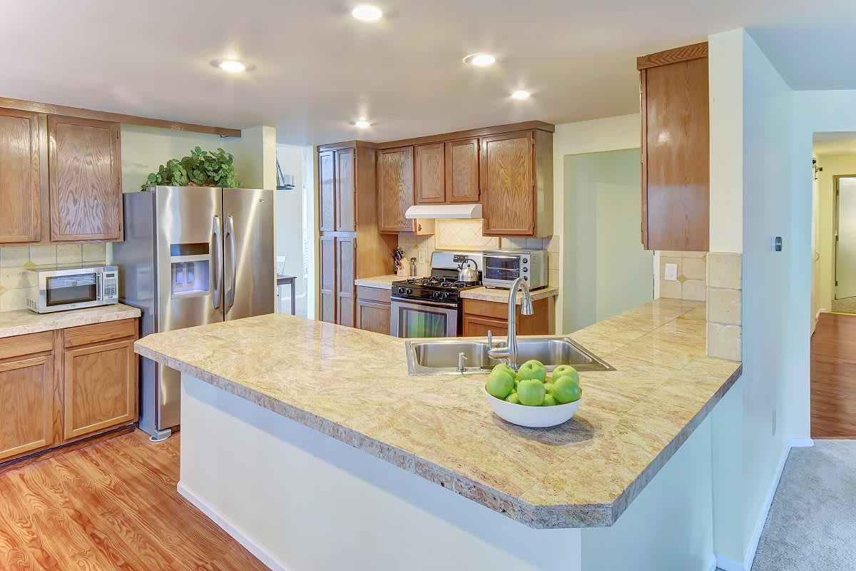 Modern kitchen with wood cabinets and stainless steel appliances.