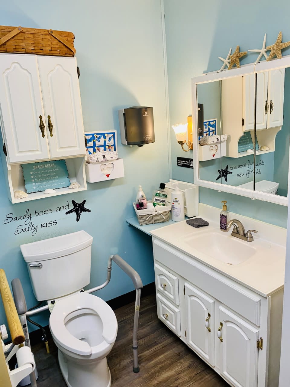 A cozy bathroom with white cabinetry and sea-themed decor.