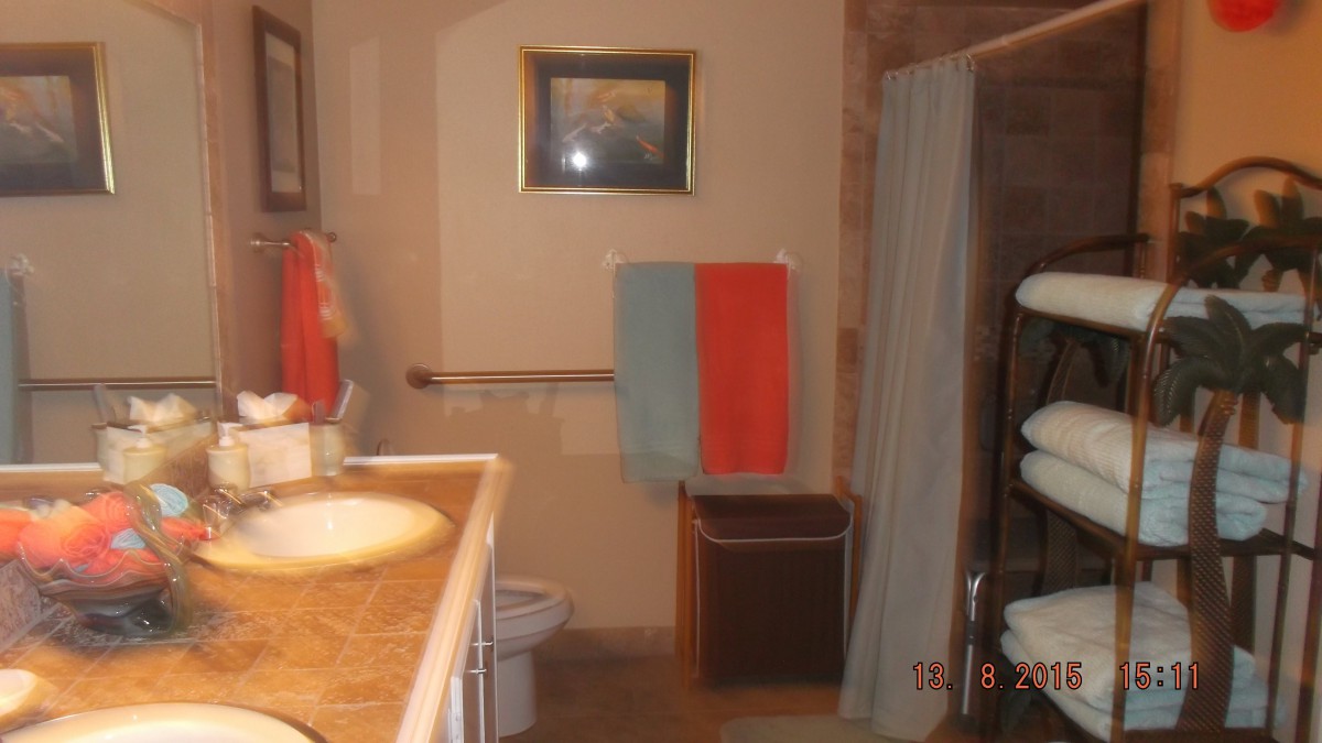A neatly arranged bathroom with colorful towels and a framed picture on the wall.
