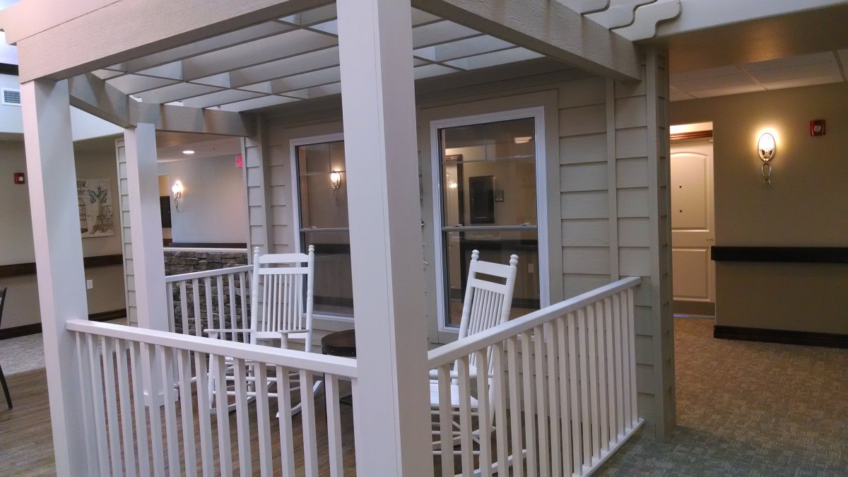 A cozy porch with two rocking chairs and white railings.