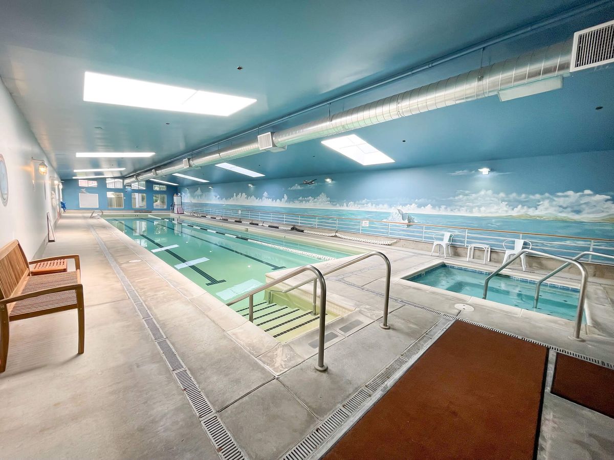 An indoor swimming pool and hot tub in a fitness center.