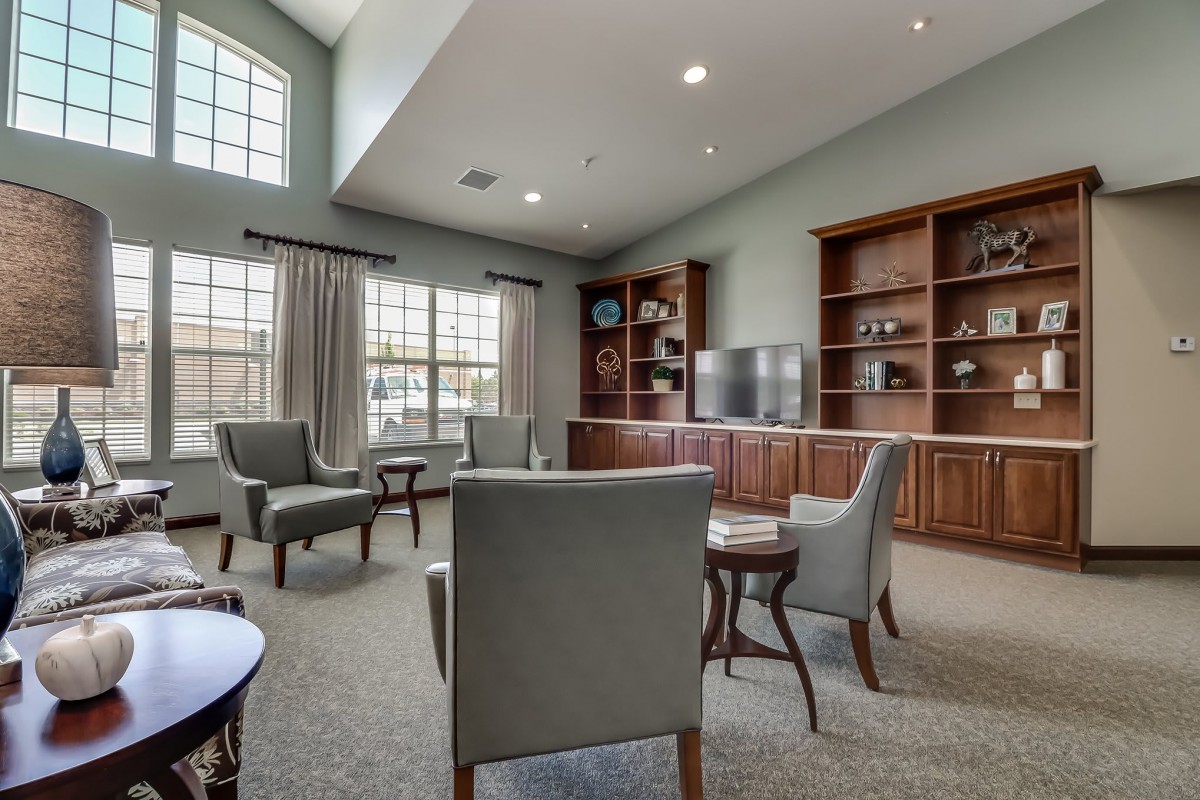 A well-lit living room with comfortable seating and built-in shelves.