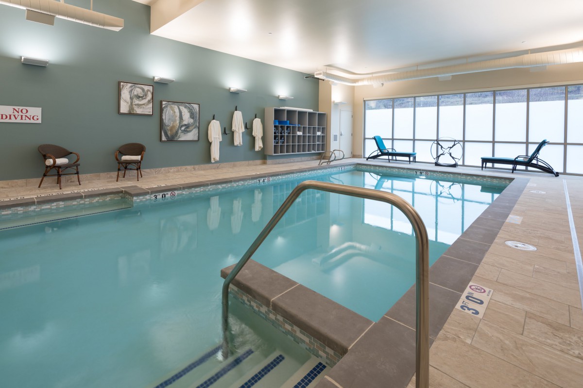 An inviting indoor swimming pool area equipped with loungers and towels for relaxation.