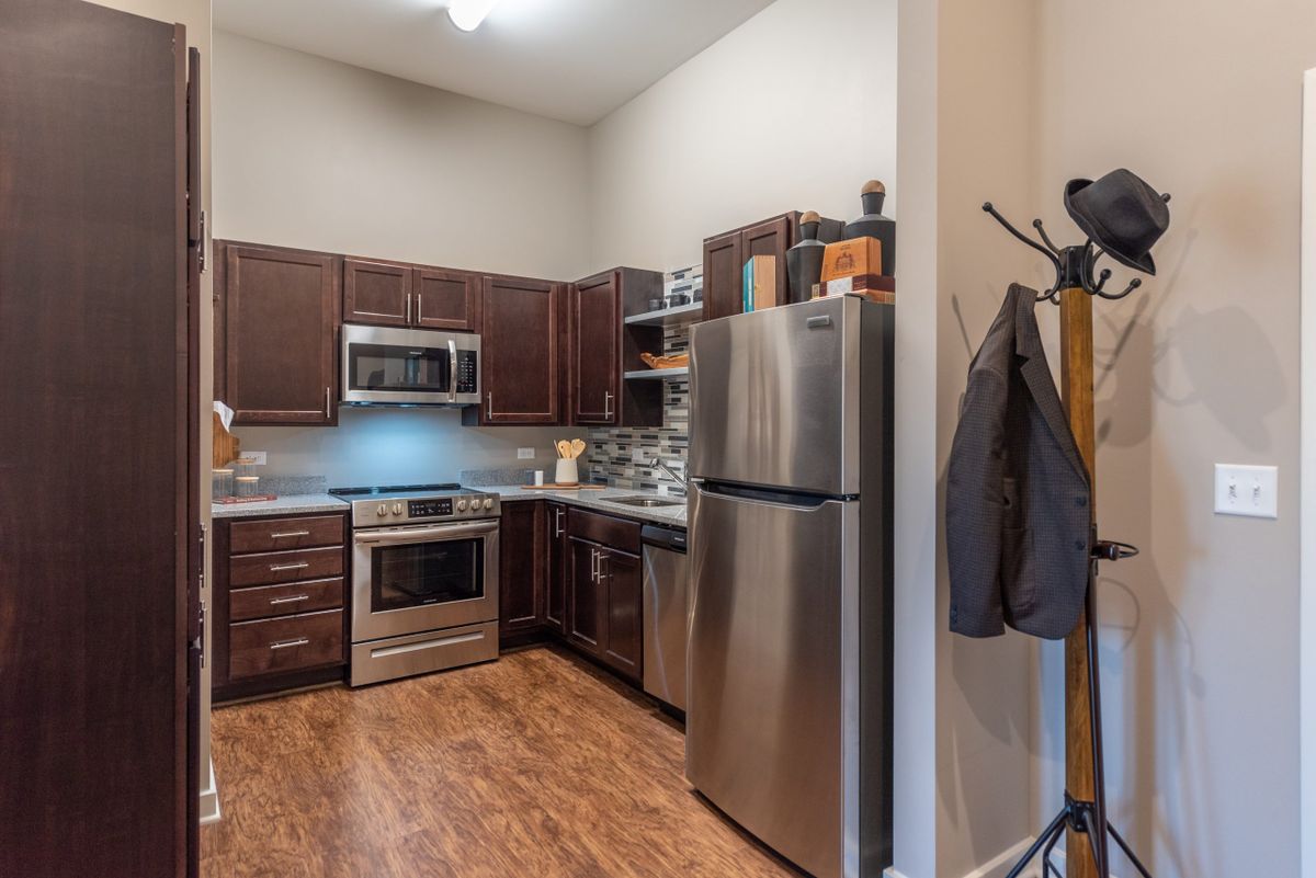 A modern kitchen featuring stainless steel appliances and wooden cabinets.