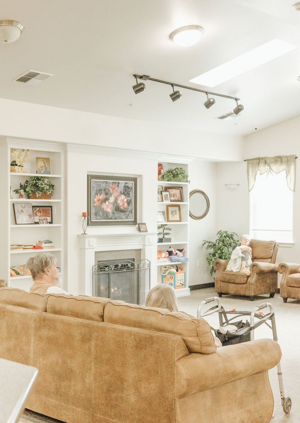 A cozy living room with a fireplace, bookshelves, and comfortable seating.