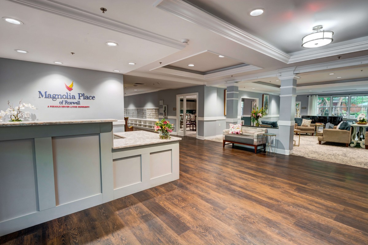 A modern and inviting lobby reception area with wooden flooring and comfortable seating.