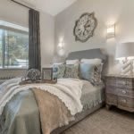 A cozy bedroom with elegant decor featuring a comfortable bed, stylish pillows, and soft lighting.