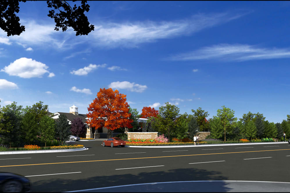 A scenic autumn road with vibrant trees and a clear sky.