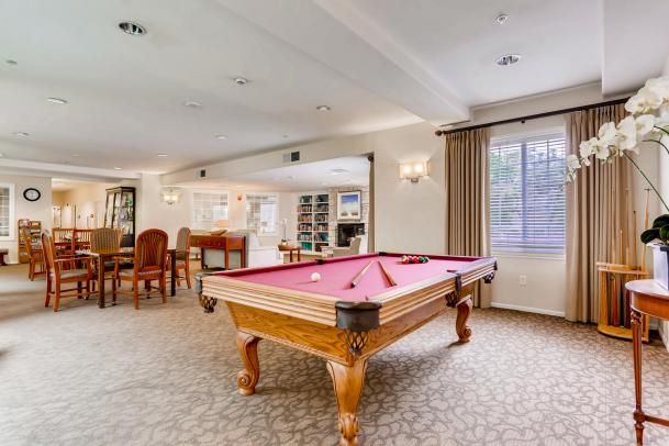 A spacious game room featuring a pool table and elegant interior decor.