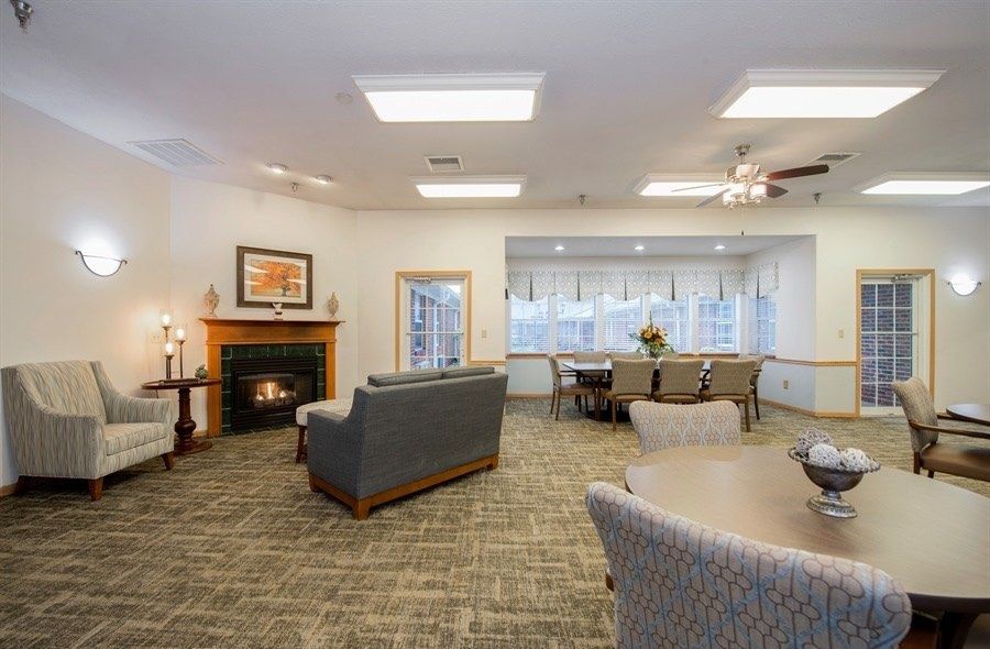 A cozy living room with a fireplace, sofa, and dining area.