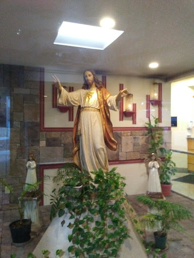A serene statue of Jesus Christ displayed in a peaceful interior setting.