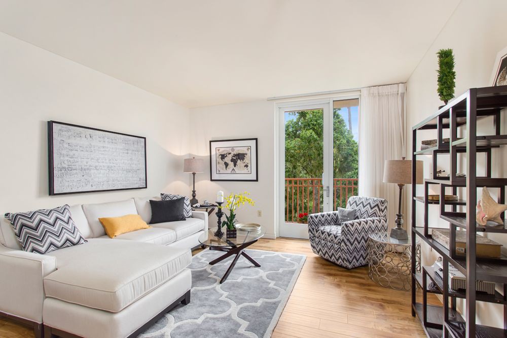 A modern and bright living room with a comfortable sofa, patterned armchair, and stylish decor.