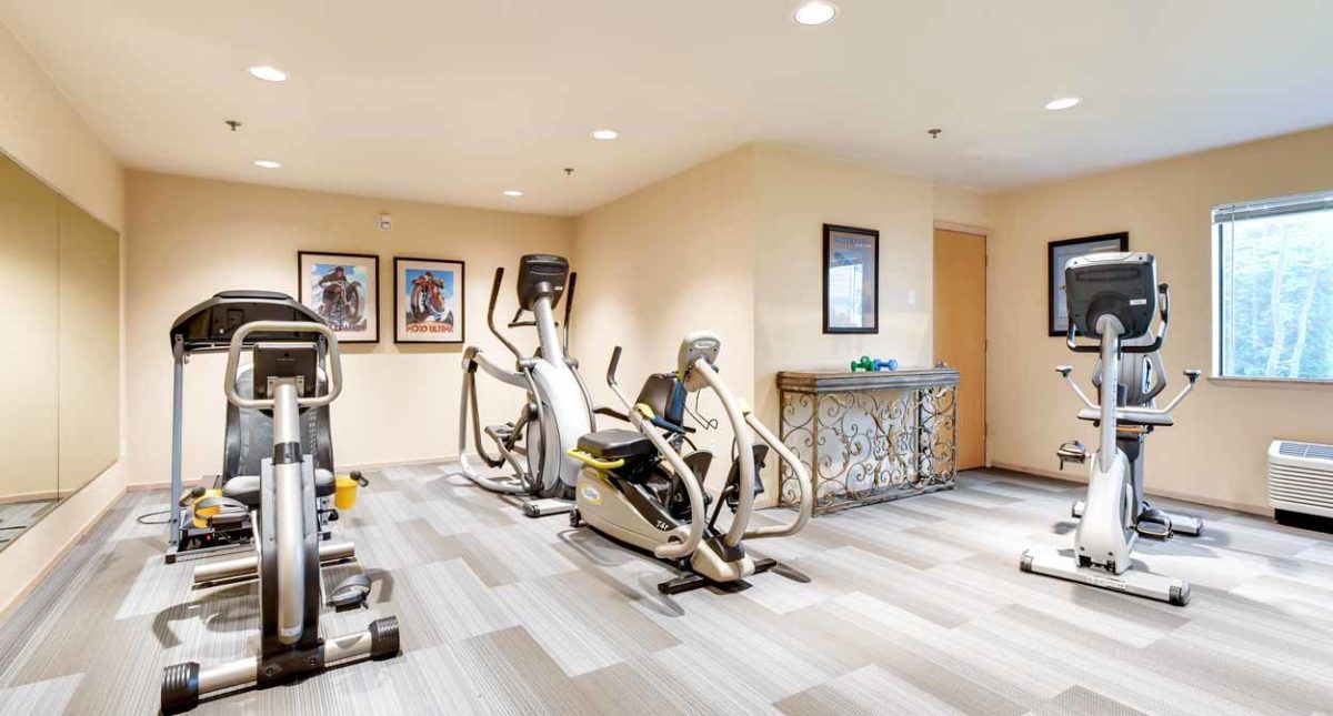 A well-lit gym room featuring exercise machines for a complete workout experience.