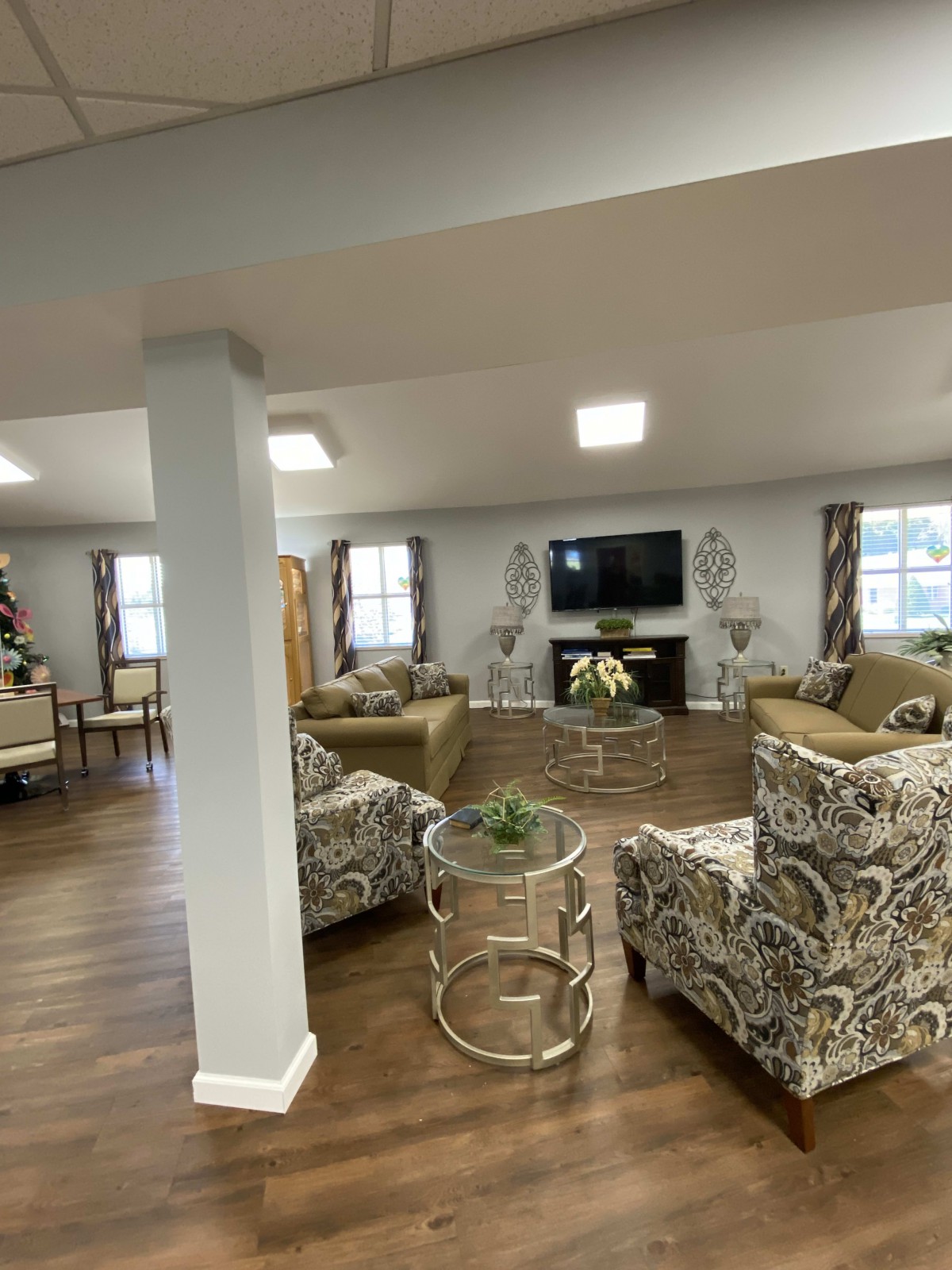A spacious and elegantly furnished living room with modern decor, featuring sofas, a large TV, and stylish coffee tables.