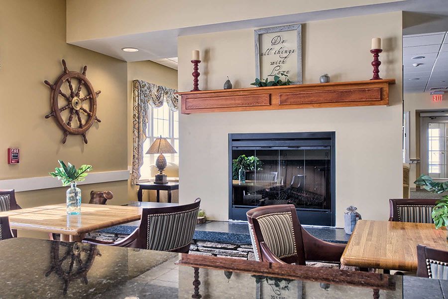 A cozy living room featuring a nautical-themed decor with a central fireplace and wooden furniture.
