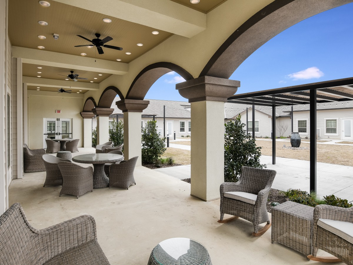 A modern outdoor patio with arched ceilings and comfortable seating.